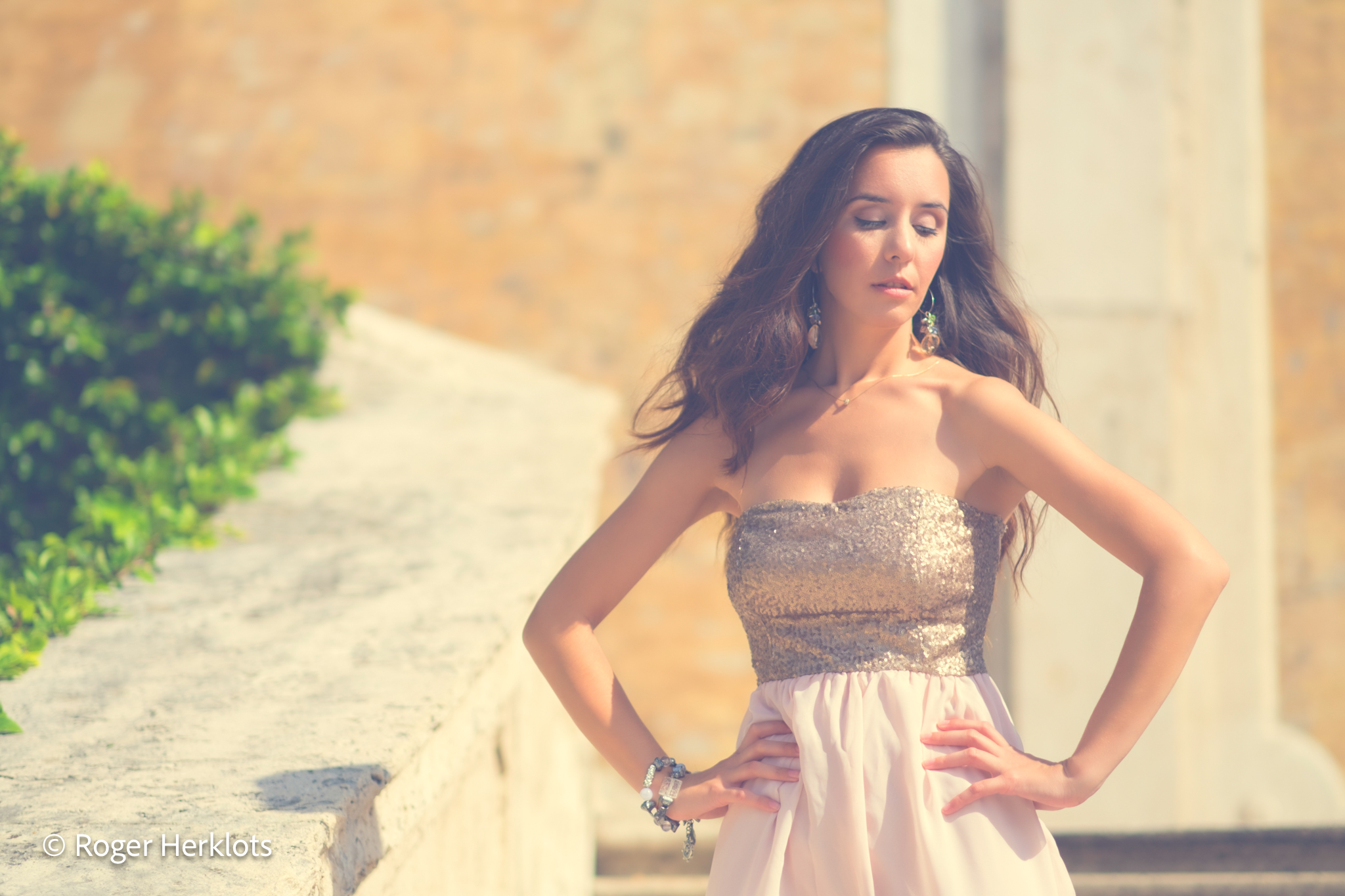 Fashion: woman in strapless dress on sunlit terrace, dreamy editorial style